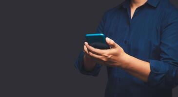 Close-up of hands businessman in a suit using a mobile phone while standing on a gray background. photo