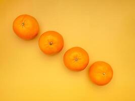 Top view of fresh oranges over a yellow background photo