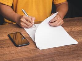 Hands of a man signing on lease contract or agreement while sitting in the office photo