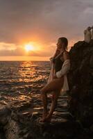 Woman Sunset Beach Rocky Coastline - Enjoying a scenic sunset by the ocean, a woman stands on a rocky coastline. photo