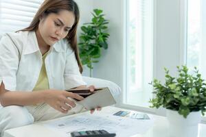 Stressed and headache asian woman with large bills or invoices no money to pay to expenses and credit card debt. shortage, Financial problems, mortgage, loan, bankruptcy, bankrupt, poor, empty wallet photo