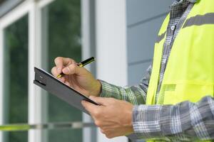 inspector or engineer is inspecting construction and quality assurance new house using a checklist. Engineers or architects or contactor work to build the house before handing it over to the homeowner photo