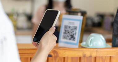 Woman use smartphone to scan QR code for order menu in cafe restaurant with a digital delivery. Choose menu and order accumulate discount. E wallet, technology, pay online, credit card, bank app. photo