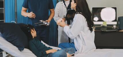 A team of doctors and nurses are working to treat a female patient in the patient's room. photo
