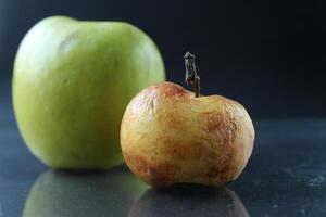 apple ugly spoiled and beautiful good on a black background copyspace photo