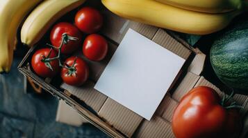 Fresh produce and blank card in a box with tomatoes, bananas, and melon photo