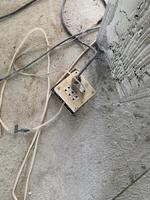 power strip on the concrete wall with wires in the house background photo