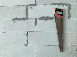 manual saw isolated on wall texture background photo