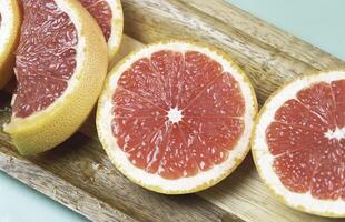 Sliced Grapefruit stacked on wooden board photo