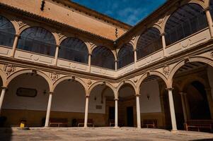 Historical courtyard with arched architecture under a clear blue sky photo