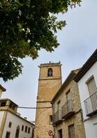 Historic stone tower surrounded by charming architecture and lush greenery photo