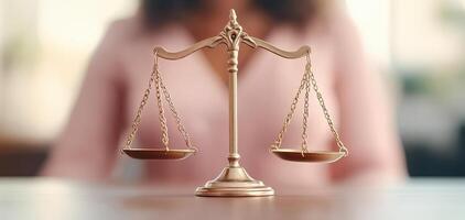 Close up of scales of justice on desk, symbolizing fairness and law. blurred background suggests professional setting, evoking sense of legal authority and balance photo