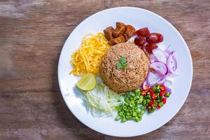Shrimp paste fried rice or Khao kluk kapi is a delicious Thai dish that combines many ingredients such as shrimp paste, mixed with Thai jasmine rice and various side dishes. photo