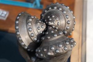 Drill bits. Perforator button for water wells. Tricone bit. Equipment for water and coal wells. Drilling three cone photo