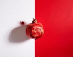 beautifully positioned pomegranates on a red and white background photo