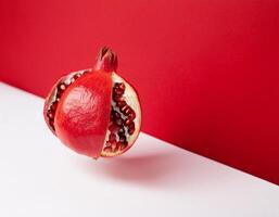 beautifully positioned pomegranates on a red and white background photo