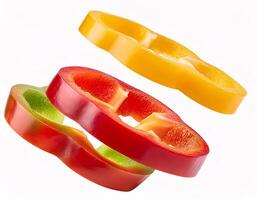 Pieces of colorful sweet peppers floating in the air, isolated on white background photo