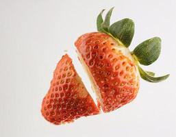 The strawberry fruit floated with a bite mark in the middle photo