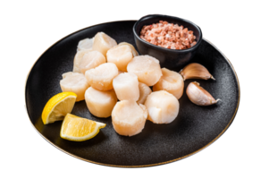 Raw sea scallops seafood on a plate with pink salt and lemon. Dark background. Top view png