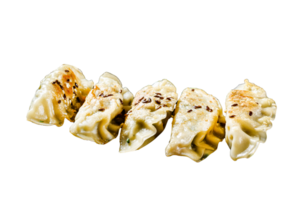Pork Potstickers on rustic black table. Dim sum on a plate. Top view. png