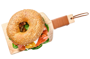 Bagel sandwich with salmon, cream cheese, spinach and egg. Gray background. Top view png