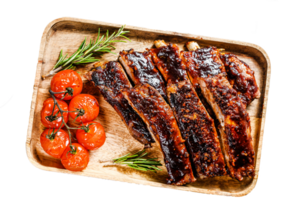 Delicious barbecued ribs seasoned with a spicy basting sauce and served with baked tomatoes. Gray background. Top view png