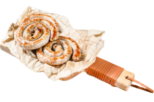 Grilled sausages spiral served on cutting board. Gray background. Top view png