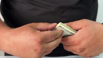 A pair of hands meticulously counts a wad of cash, reflecting the stress of awaiting important bills. The setting is casual, indicating a personal financial situation video