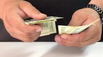 Hands are methodically counting dollar bills, reflecting a focus on money management. The individual appears engaged, showcasing diligence in handling cash video