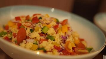 A bowl of couscous salad with vegetables and tomatoes photo