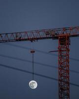 full moon and construction crane at night photo