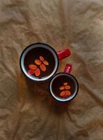 two mugs of tea, an autumn leaf in the mug photo