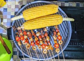 A grill with corn and chicken on it photo