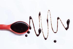 Chocolate spoon splash on white background. photo