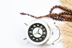 Ramadan concept alarm clock, white background. concept of limiting food intake. photo