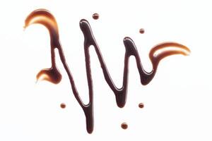 Chocolate syrup drizzle isolated on white background. Splashes of sweet chocolate sauce. Top view. photo