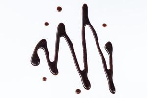 Chocolate syrup drizzle isolated on white background. A splash of sweet chocolate sauce. Top view. photo