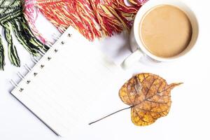Top view photo of workspace paper sheet envelope on notepad computer mouse cup coffee cup and scarf on isolated gray background with copy space