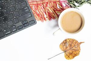 Autumn business concept. Top view photo of cup of coffee with yellow maple leaf croissant computer mouse keyboard and scarf on isolated background with copy space