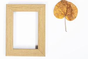 Autumn composition. Gold leaf, photo frame on white background. Autumn, autumn concept. Flat lay, top view, copy space