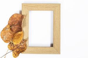 Autumn composition. Photo frame, maple leaves, on white background. Flat lay, top view, copy space.
