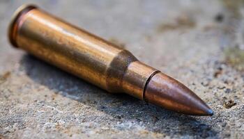 macro view of a weathered bullet casing with copper tip resting on a textured concrete surface in natural lighting photo