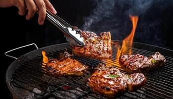 close-up of hands flipping thick marinated pork chops on a flaming charcoal grill, with smoke rising and flames glowing against a dark background photo