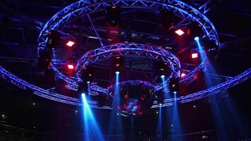night disco club with neon blue violet red light, disco mirror ball and bright floodlight with round metal frame luminous construction video