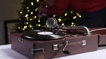 Old gramophone playing christmas music with decorated tree in background video