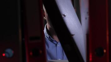 detective brilla un Linterna en carpetas con documentos en un estante. video