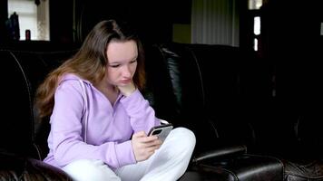 Happy young asian woman relax on comfortable couch at home, typing chat message on smartphone, smiling girl use cell phone chatting, searching information on browser wireless internet, online shopping video