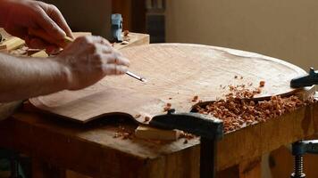Luthier working with a gouge manufacturing a new instrument video