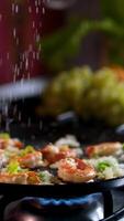 add black pepper to the shrimp Chef adds black pepper to shrimps cooking in pan with butter herbs and tomatoes. High quality 4k footage video