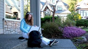 Portrait of a girl in a leather jacket with a backpack standing on the street in the background of his new home. video